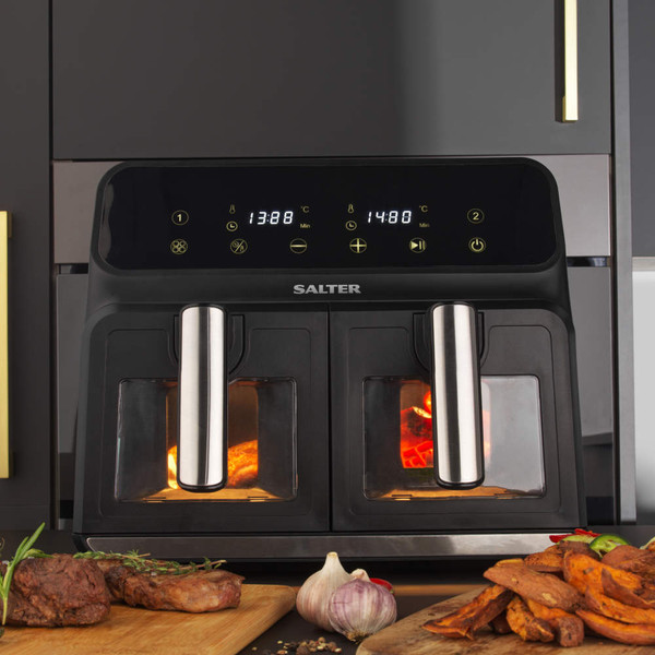 Black dual basket air fryer with digital display, shown cooking food on a kitchen counter