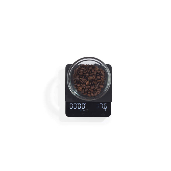Digital coffee scale with glass bowl of coffee beans, display showing 17.6 grams.