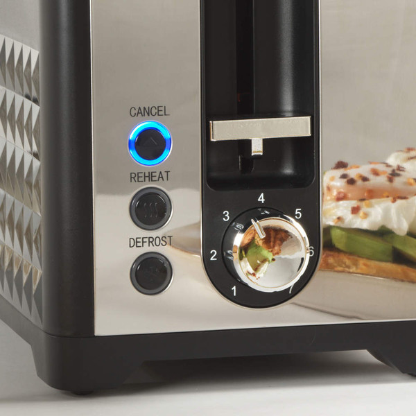 Black and silver toaster with illuminated reheat and defrost buttons, close-up