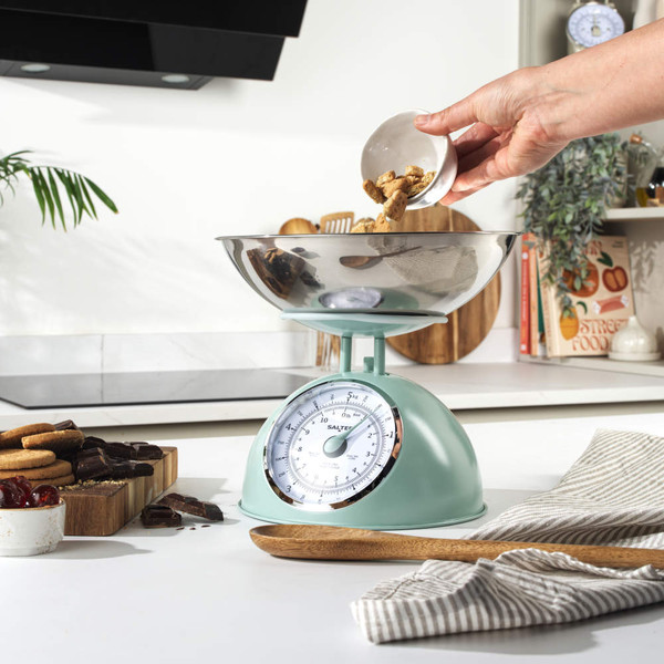 Sage green mechanical kitchen scale with round dial, shown from above.