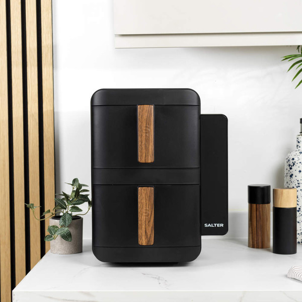 Two black dual air fryers with wood accents on kitchen worktop