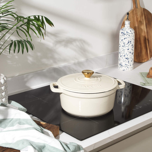 Cream cast iron casserole dish with gold knob and handles, lid on, by Salter