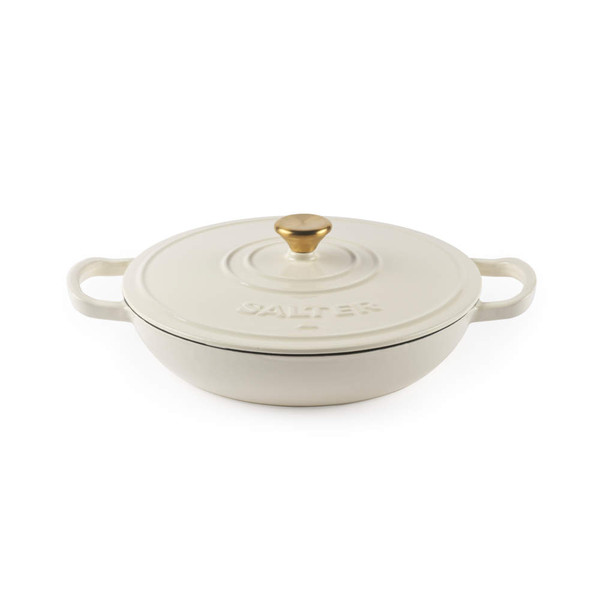 Cream cast iron casserole dish with gold knob and handles, lid on, by Salter