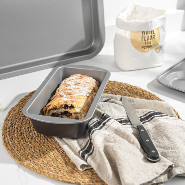 Non-stick loaf tin with baked strudel on kitchen worktop