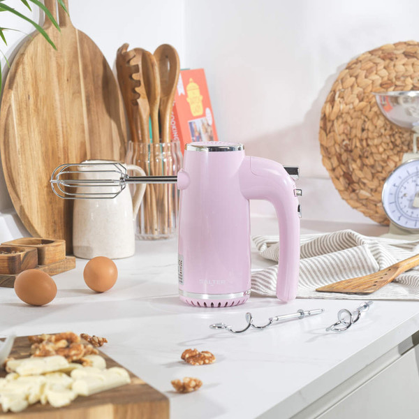 Pink retro hand mixer with attachments shown on box packaging