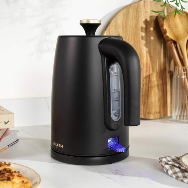 Matte black electric kettle with gold lid being poured