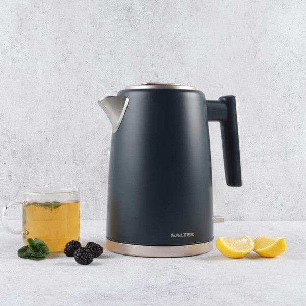 Grey electric kettle with Salter logo, beside cup of herbal tea, blackberries and lemon wedges