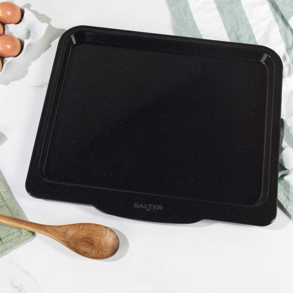 Black non-stick oven tray, photographed top down with logo on handle