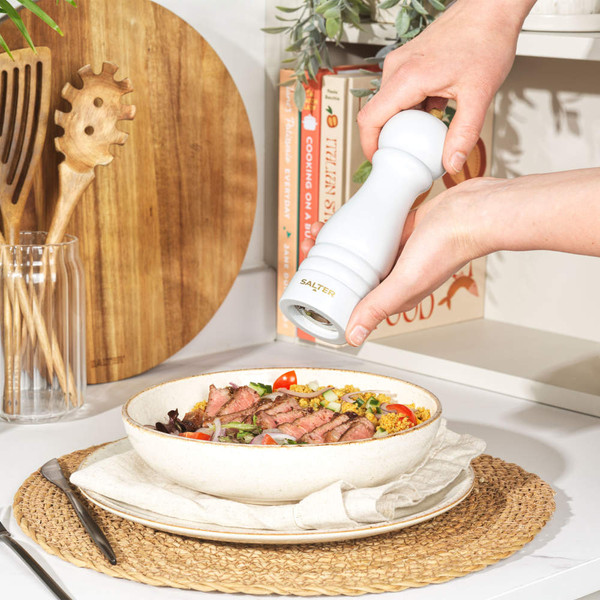 White Salter salt grinder being filled with sea salt in a kitchen setting