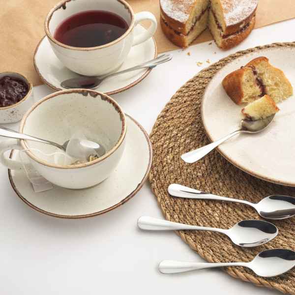 Overhead view of two cups and saucers with tea, Victoria sponge cake, and jam.