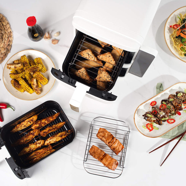 White and gold double basket air fryer with open drawers, angled side view