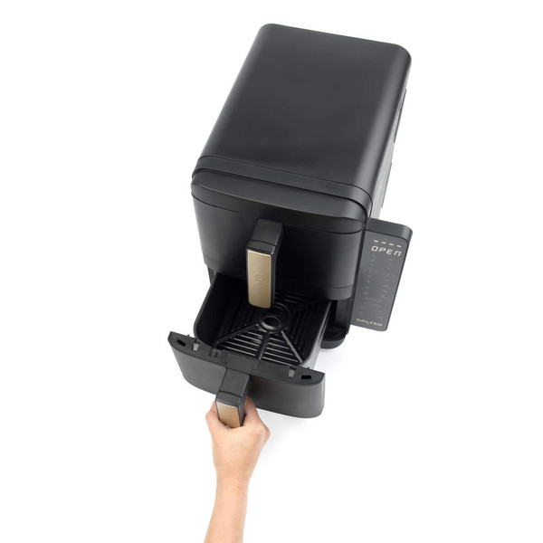 Hand removing black and gold air fryer drawer, basket shown extended from appliance