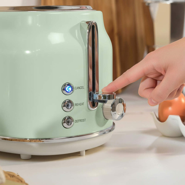 Pastel green 2-slice toaster with cancel, reheat, and defrost buttons, hand pressing lever.