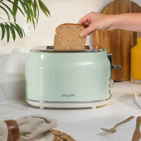Green Salter toaster on kitchen counter with hand inserting slice of wholemeal bread