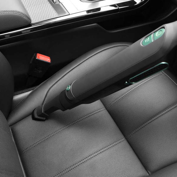 Cordless handheld vacuum cleaning car seat, close-up shows slim nozzle in use