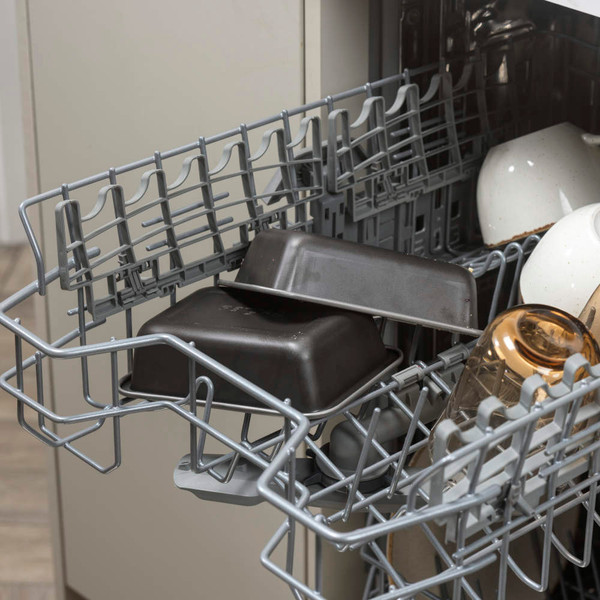 Non-stick loaf tins in dishwasher top rack, shown with mugs and glasses.