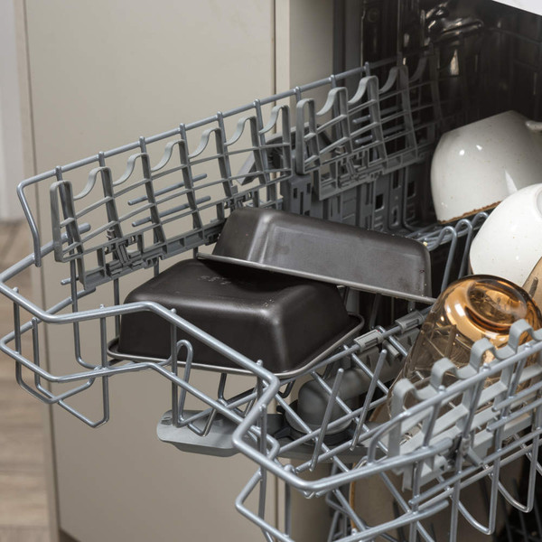 Non-stick loaf tins in dishwasher top rack, shown with mugs and glasses.
