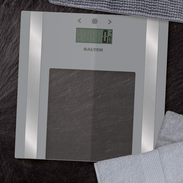 Silver glass digital bathroom scale with LCD display, shown on black surface.
