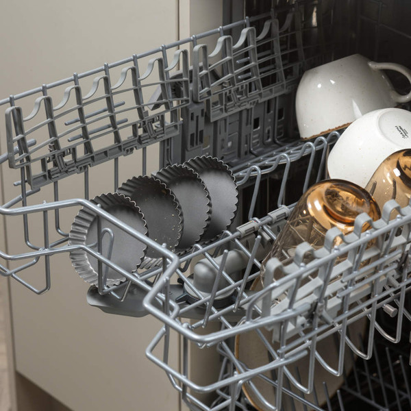 Grey fluted tart tins in dishwasher upper rack for easy cleaning