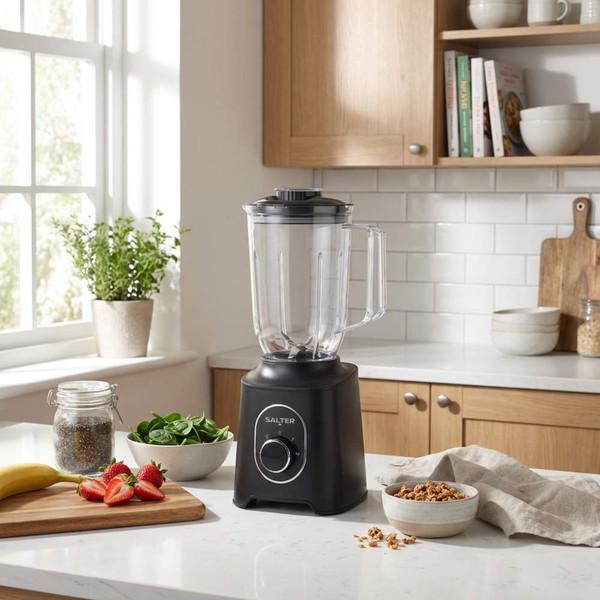 Black countertop blender in modern kitchen, shown with smoothie ingredients.