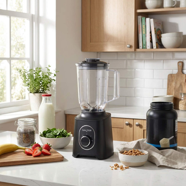 Black countertop blender in modern kitchen with fruit and breakfast ingredients