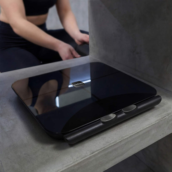 Black smart bathroom scale on concrete surface, fitness setting, shows scale details