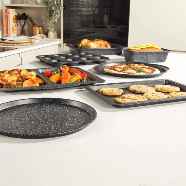 Set of black non-stick baking trays with food, assorted shapes for roasting, baking, and pizza.