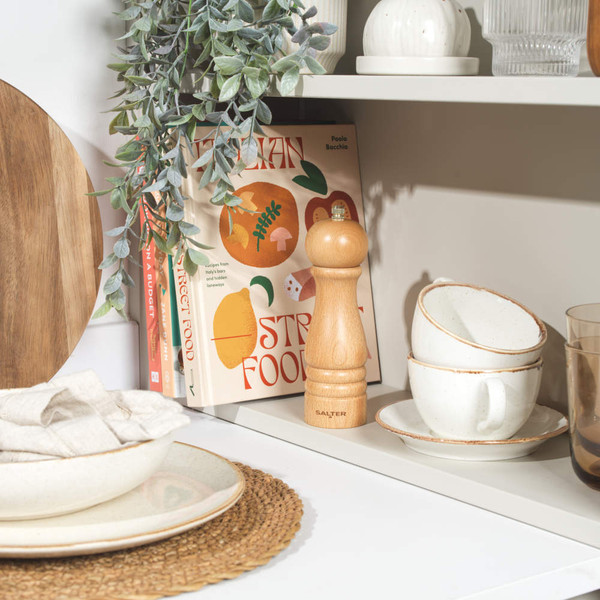 Wooden manual salt or pepper mill, light natural beech finish, lying on its side