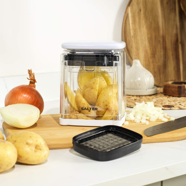 Salter potato and onion chopper on kitchen counter with vegetables, for food preparation.