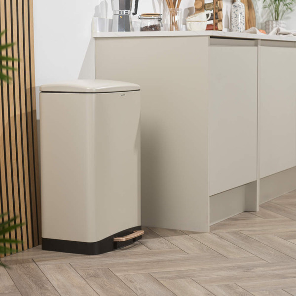 Cream pedal bin with black base in modern kitchen setting