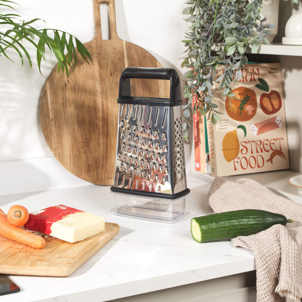 Stainless steel box grater with black handle, shown with two clear storage containers.