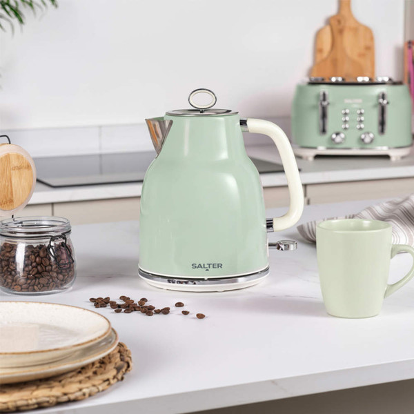 Green electric kettle on kitchen counter, next to matching mug and coffee beans.