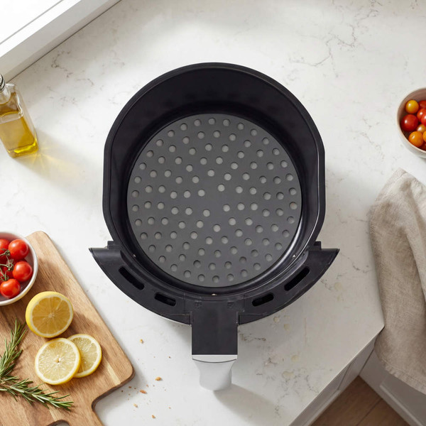 Top view of empty black air fryer basket on kitchen counter