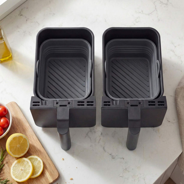 Twin grey air fryer baskets shown empty on kitchen counter, viewed from above.