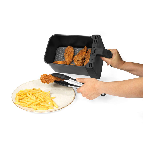 Air fryer basket serving breaded chicken and chips onto plate