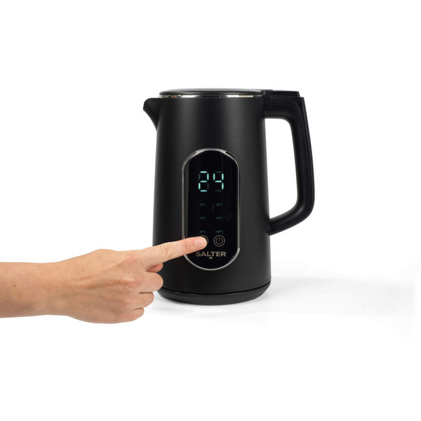 Black electric kettle with digital temperature display, showing a hand pressing the control panel.