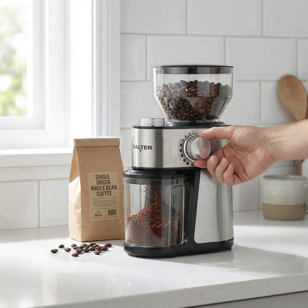 Electric coffee grinder in stainless steel with beans and ground coffee, in kitchen setting