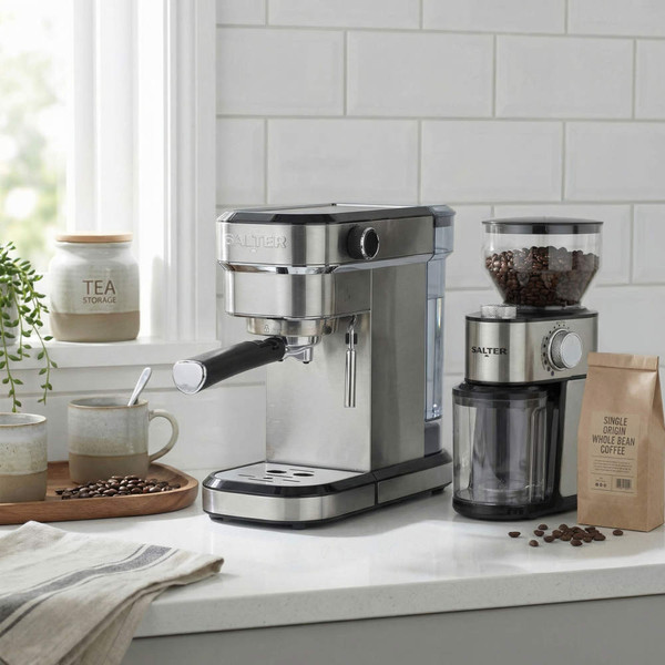 Silver espresso coffee machine and grinder on kitchen worktop with cups and coffee beans