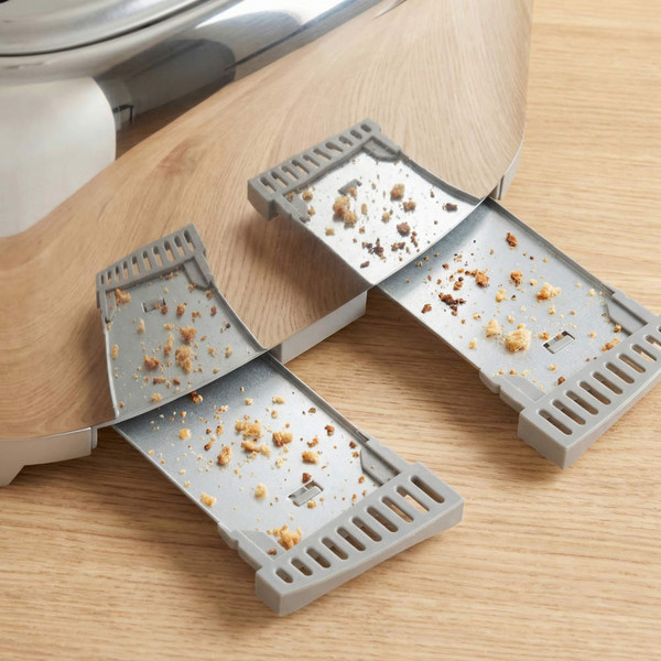 Toaster with two crumb trays extended, showing crumbs for cleaning