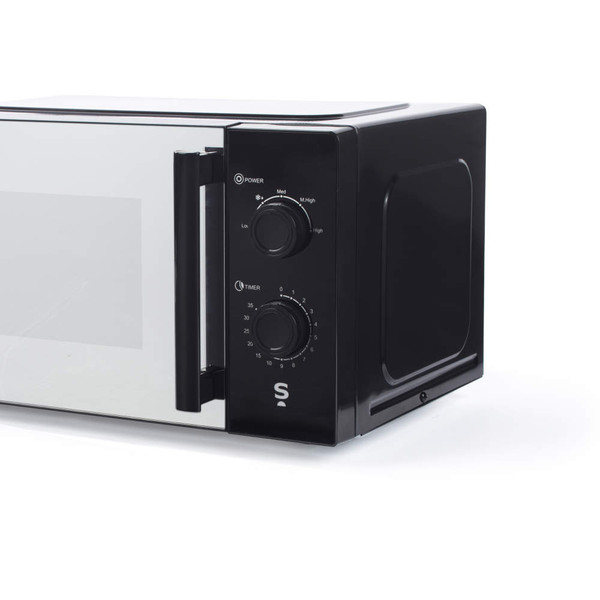 Black microwave oven with manual dials, shown from front right angle