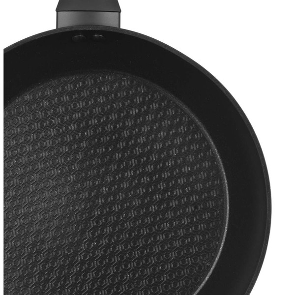 Black non-stick frying pan with honeycomb textured base, top view close-up