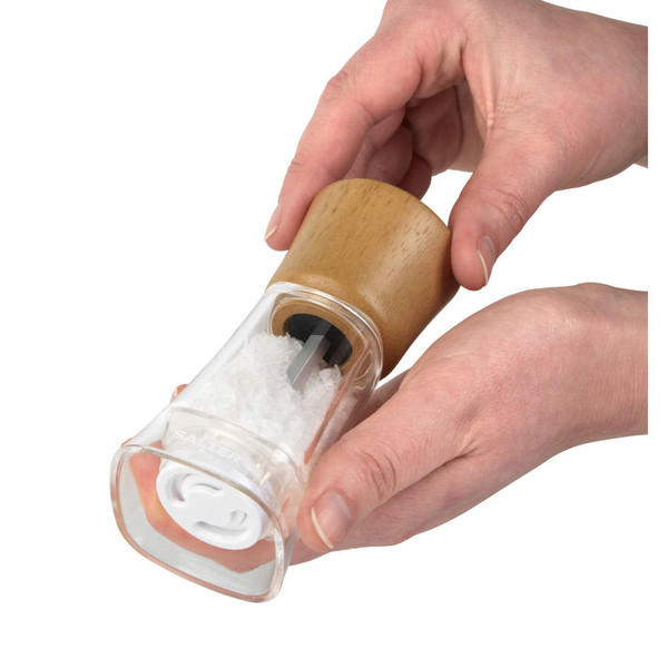 Wood and clear acrylic salt mill, hand-held in use