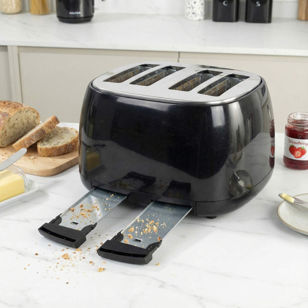 Black 4-slice toaster with crumb trays extended, shown on kitchen counter.