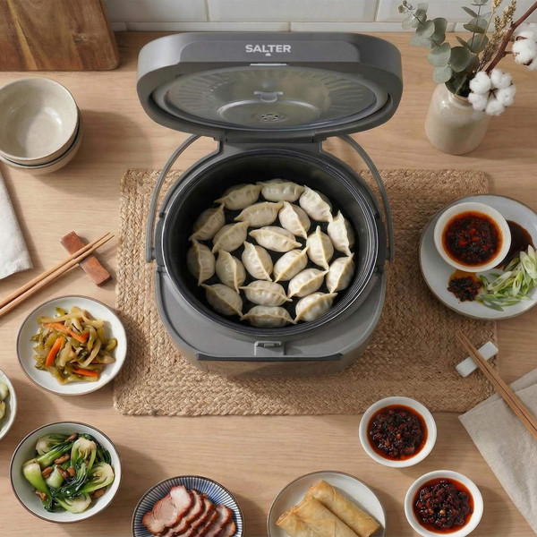 Grey Salter multi-cooker with dumplings inside, shown with side dishes on table
