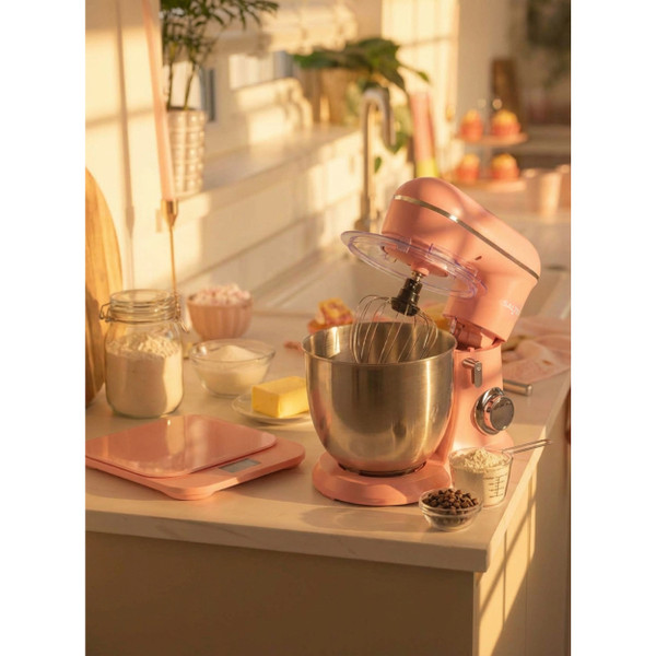Pink stand mixer with stainless steel bowl on kitchen counter, shown in natural light