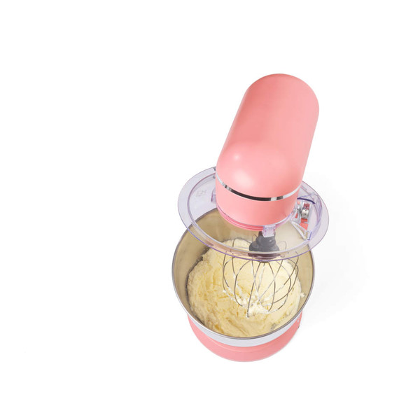 Pink stand mixer with metal bowl mixing cake batter, shown from above.