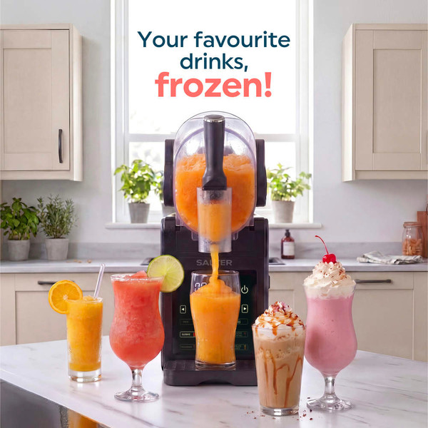 Frozen drink maker dispensing strawberry slush into glasses on kitchen counter