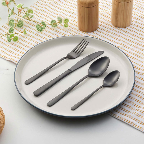 Set of matte black cutlery arranged on white plate