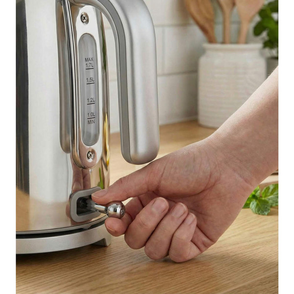 Chrome electric kettle close-up, showing hand switching it on with clear water level indicator