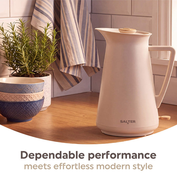 Beige electric kettle with wood accents pouring hot water into black mug